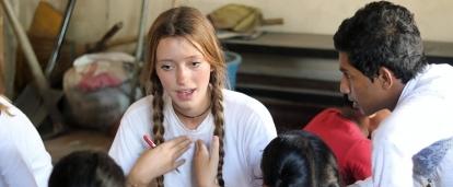 Een Projects Abroad vrijwilliger doet Kinderopvang werk in Sri Lanka in een groep en leidt een les met jonge kinderen. Een vrijwilliger doet werk binnen de gemeenschaps in Sri Lanka in een groep, en leert jonge kinderen Engelse zinnen.